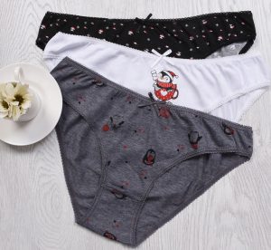 A stylish flat lay of colorful women's panties on a wooden surface, showcasing fun patterns.
