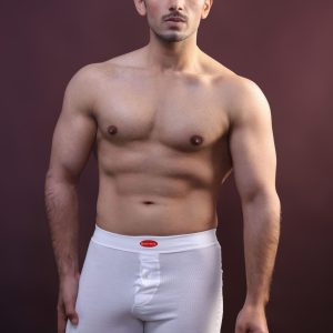 Home Portrait of a muscular man standing in a studio wearing white underwear.